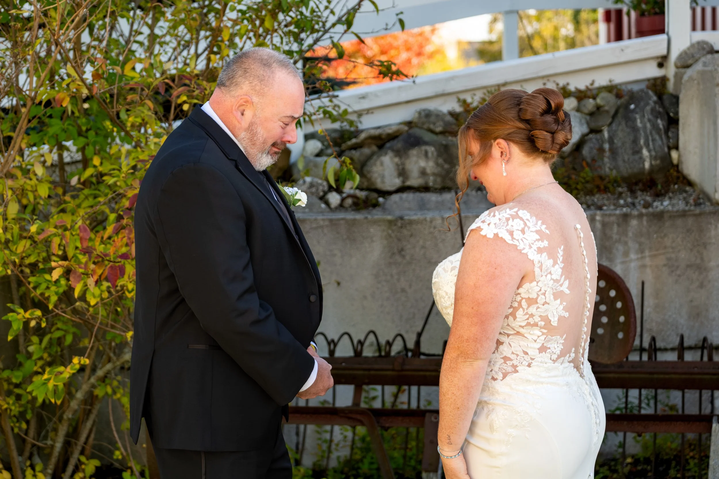 Erika's dad with his back turned as she reaches toward him in her wedding dress at the Maine Wedding Barn and Event Center in Minot Maine fall wedding photography VMG Productions