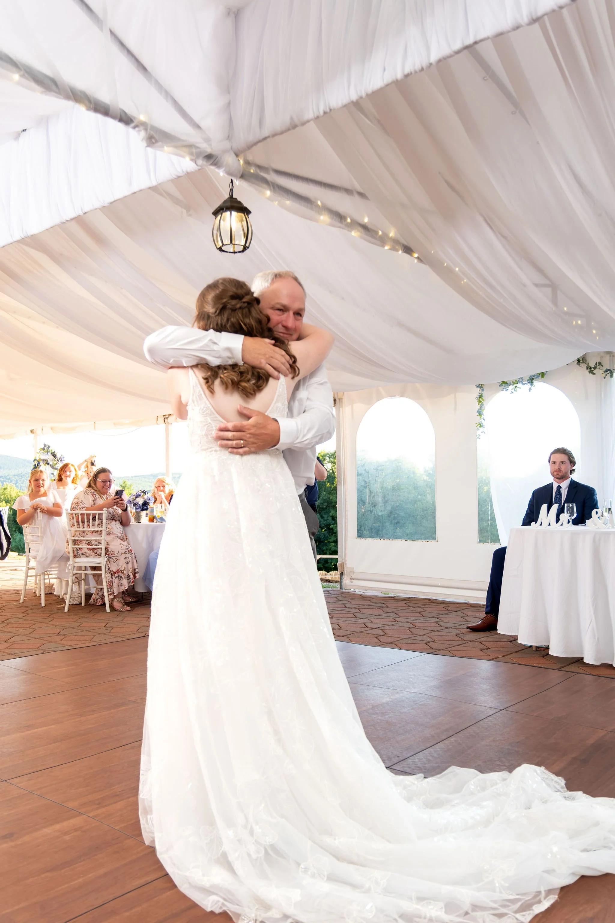 Hollie hugging her dad during their father daughter dance on the tent dance floor at The Lucerne Inn in Dedham Maine summer wedding photography VMG Productions