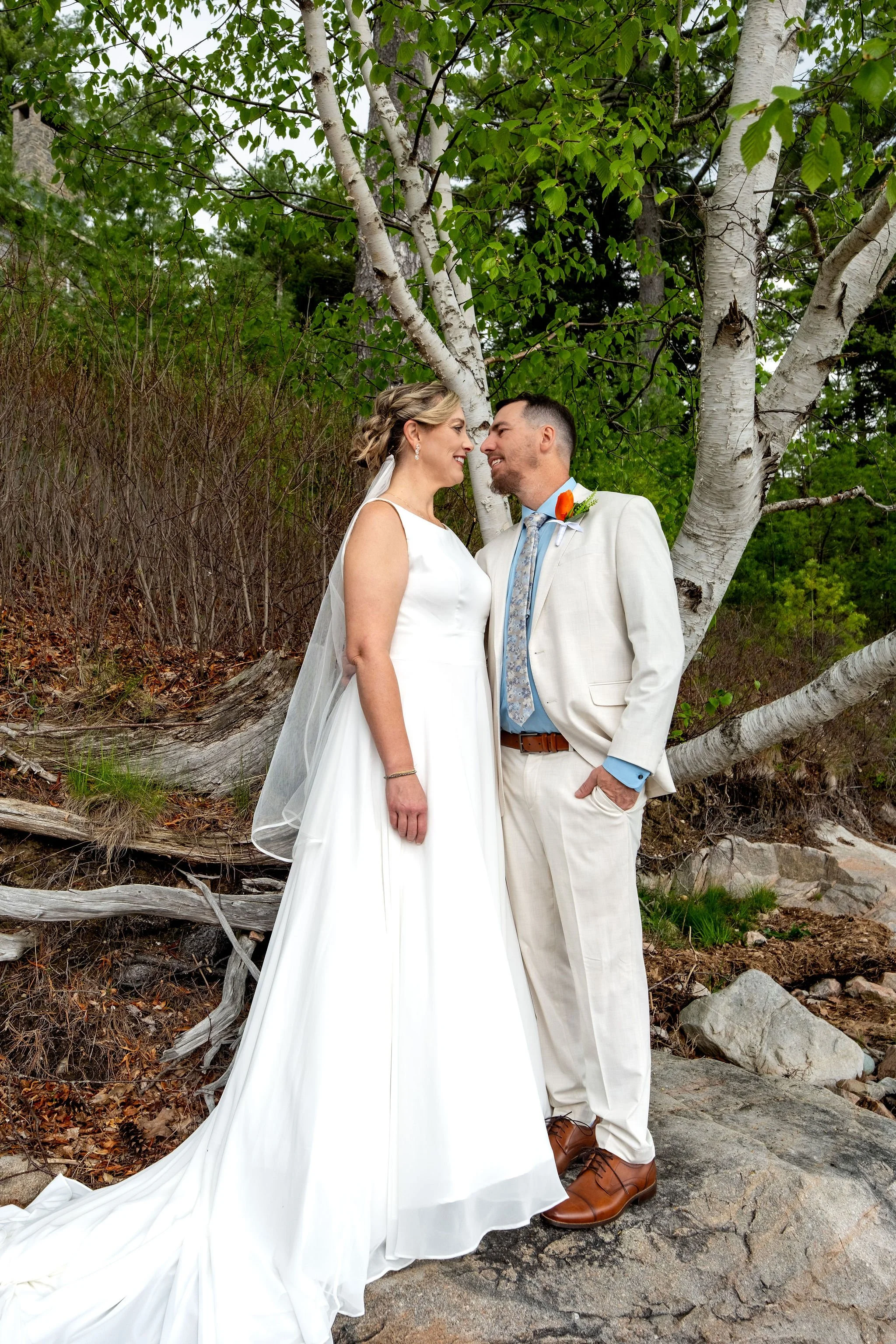 Alli and Adam Baudoin standing together among the birch trees on the shoreline at their Mount Desert Maine private residence spring wedding photography VMG Productions