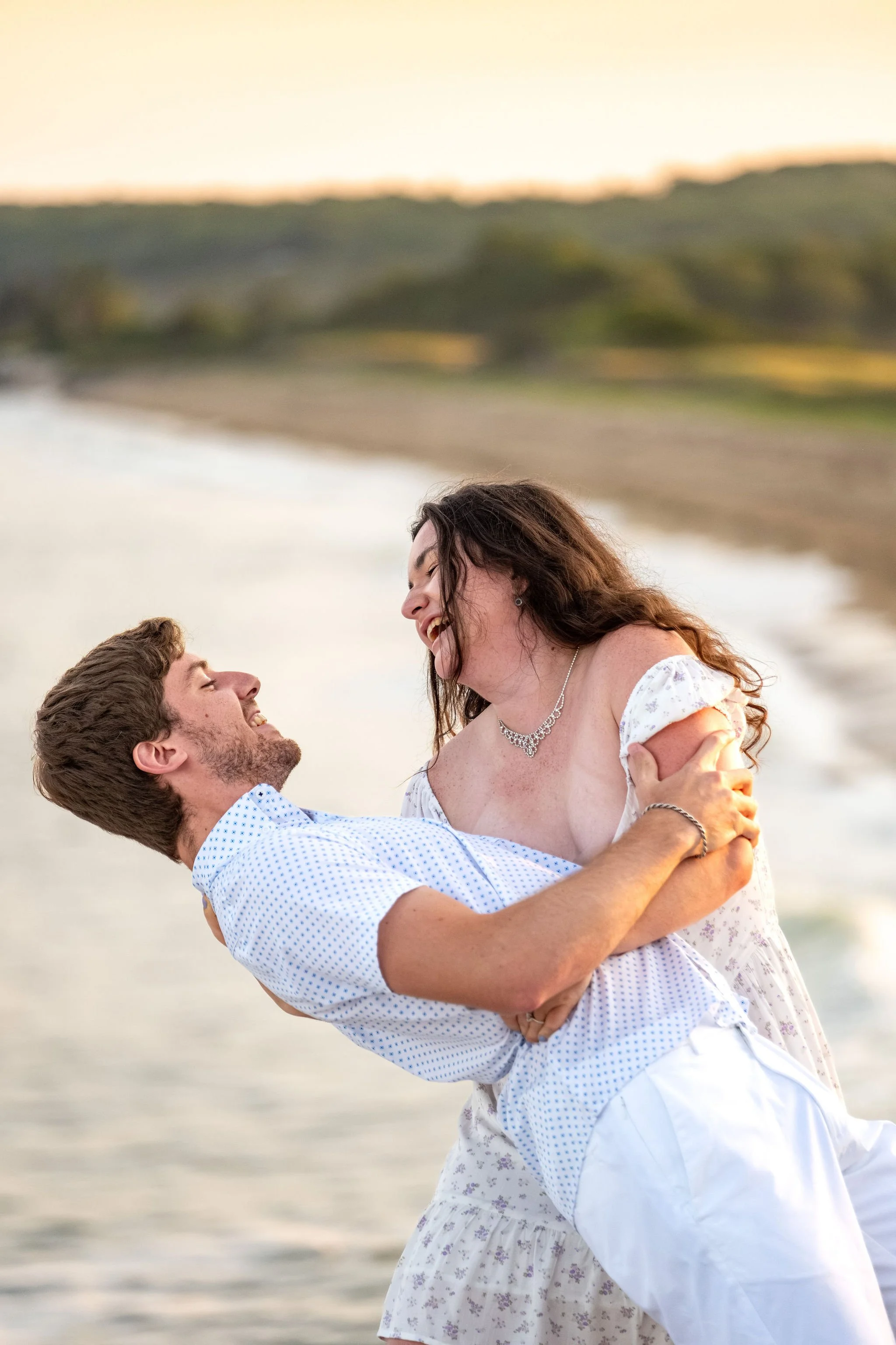 Lucas dipping Kirstie back over the beach and surf below the headland at Reid State Park in Georgetown Maine engagement photography VMG Productions