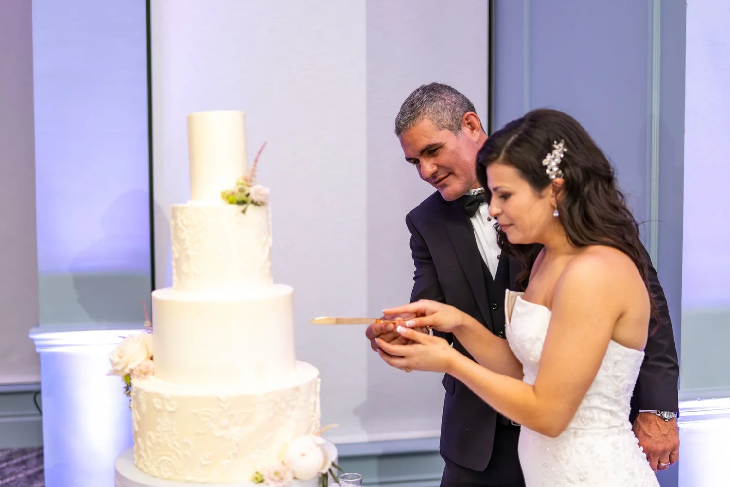 Nicole and Alexey cutting their wedding cake with the gold knife at Portland Sheraton at Sable Oaks South Portland Maine summer wedding photography VMG Productions
