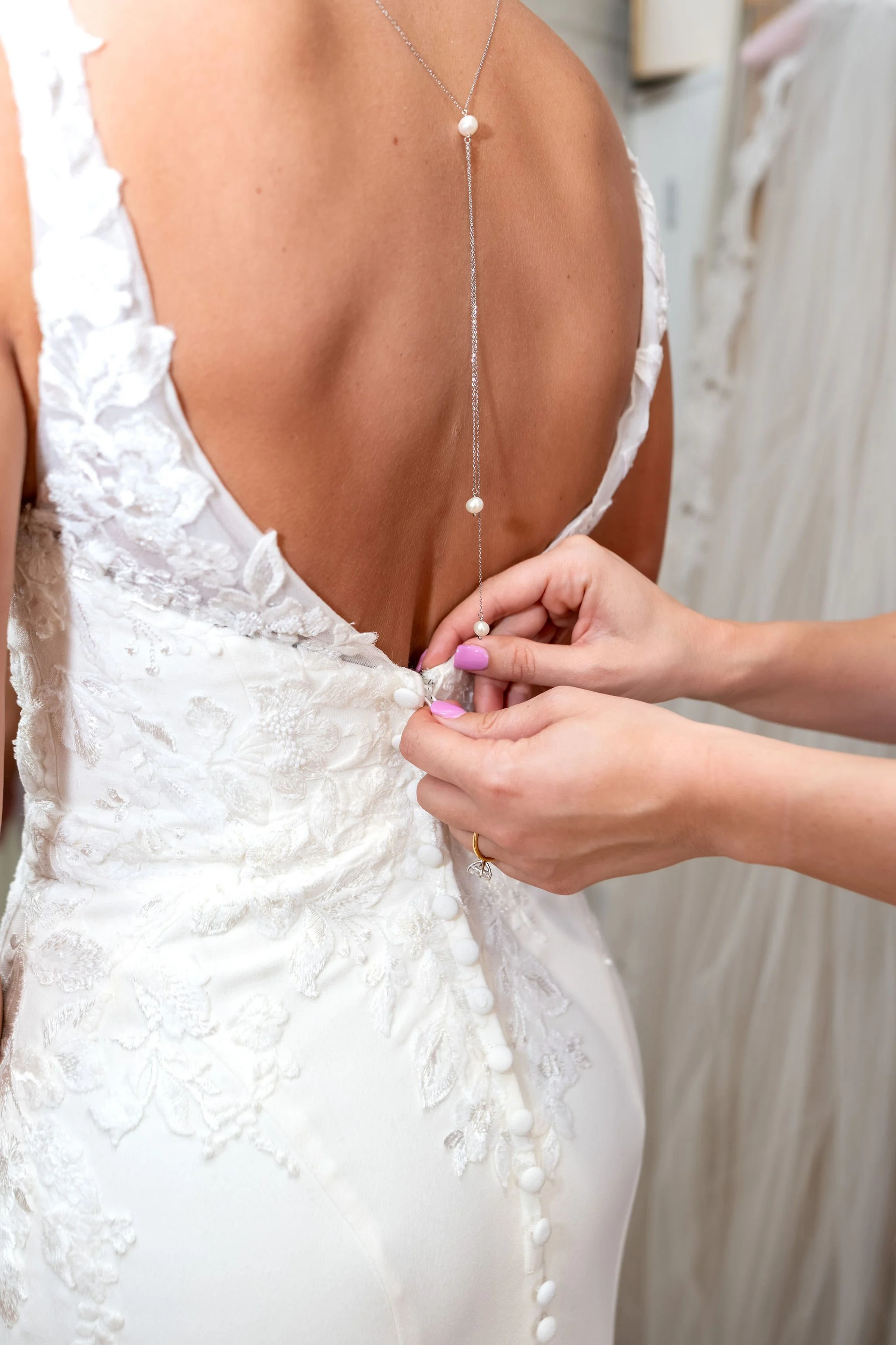 Beth and Cameron detail of the bride's back necklace as her gown is buttoned at Augusta Country Club Manchester Maine spring wedding photography VMG Productions
