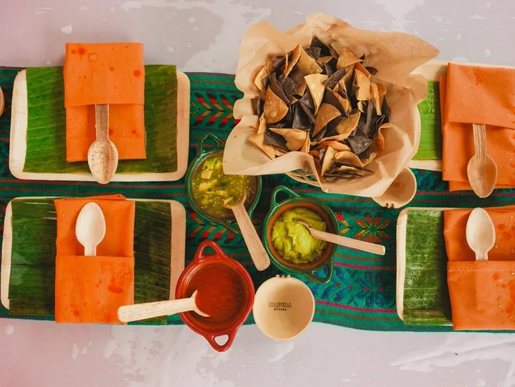 A table with chips, guacamole, and salsa.
