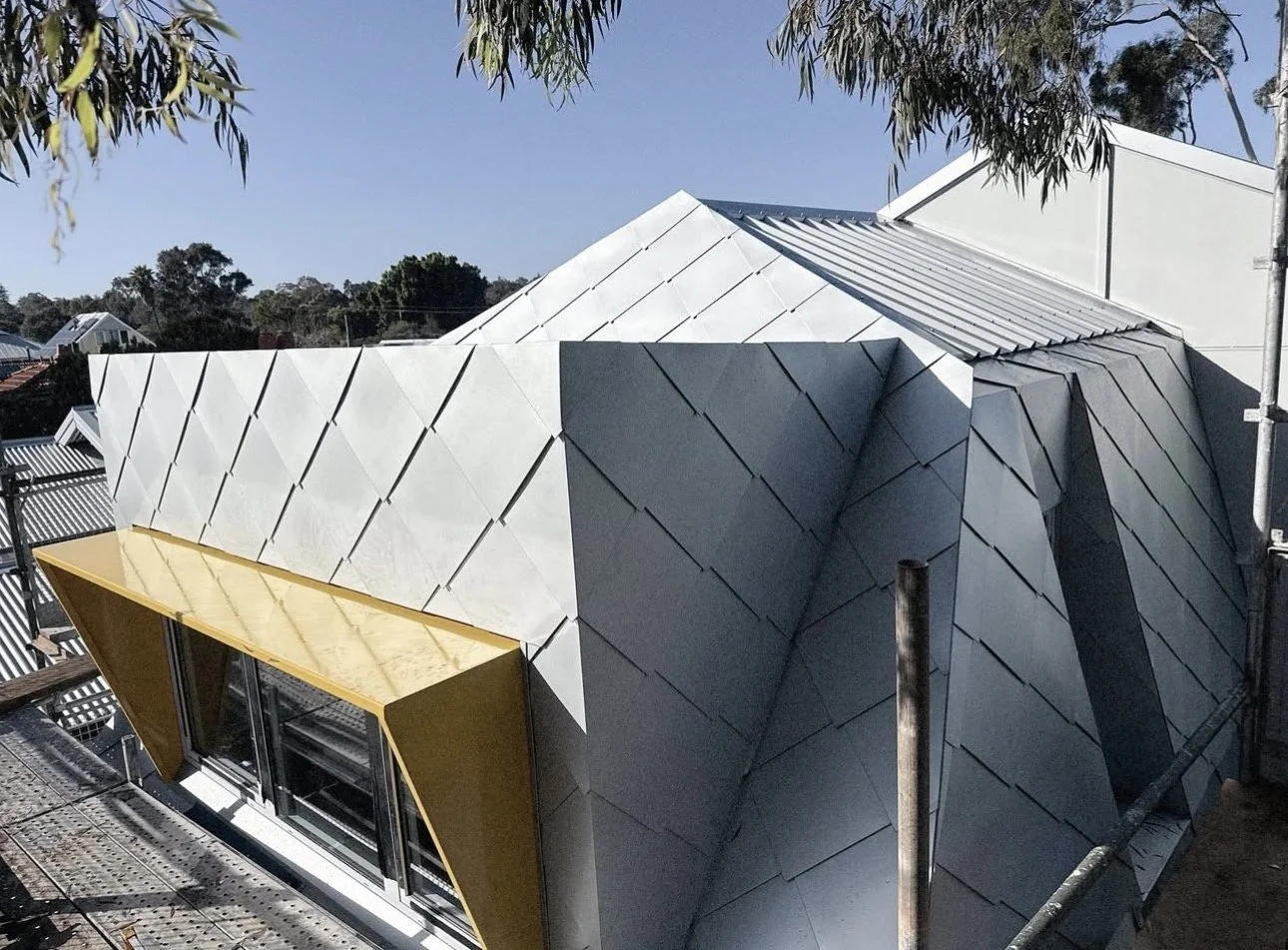 Diamond shingle roof and yellow window hood on site