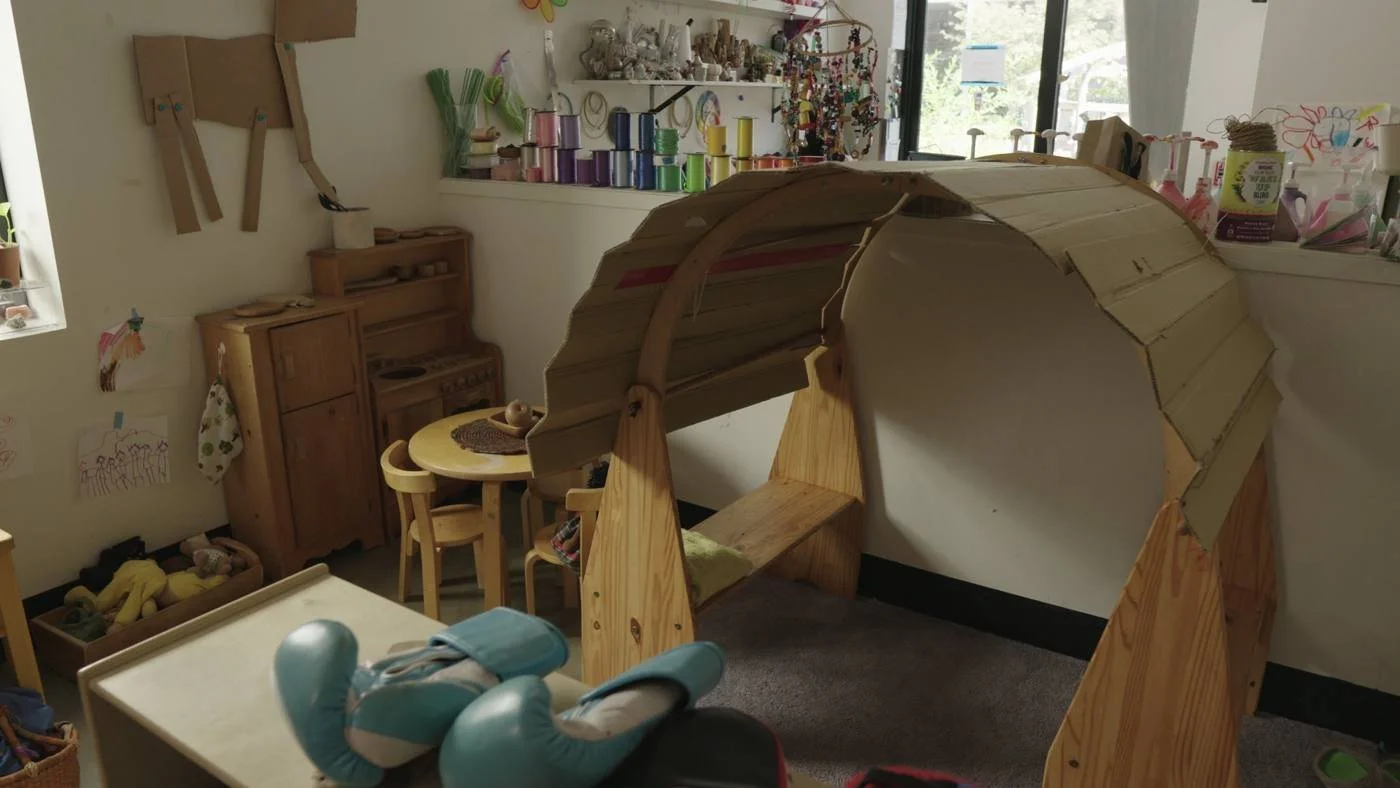 A wooden play tunnel in a Wow and Flutterville classroom