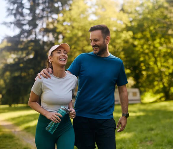 Happy active couple walking together outside and smiling indicating successful Belle Isle pain management care