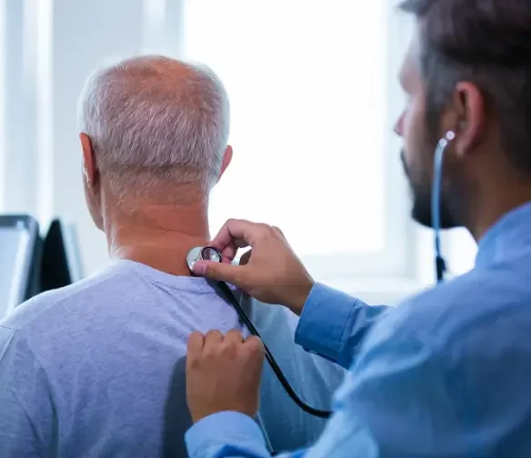 Midtown OKC car accident doctor examining neck pain of a male patient