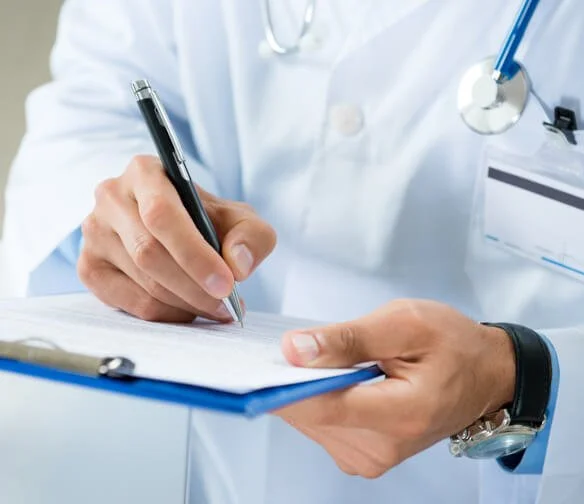 Car accident doctor in Oklahoma City filling out a medical form