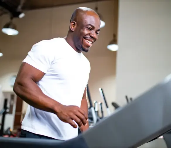 Man running on treadmill after Norman pain management doctor care.
