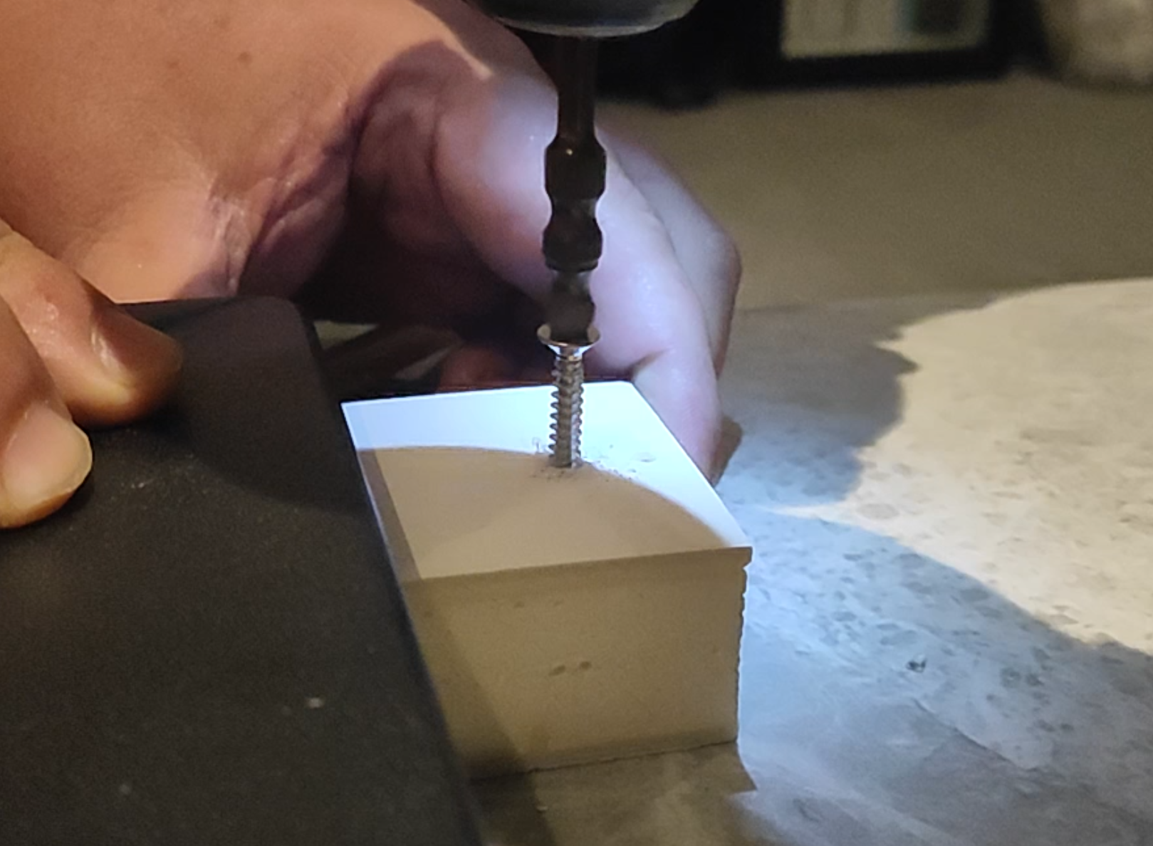 Internal demonstration of a self-tapping screw engaging with a Wakebath textured shower tray sample