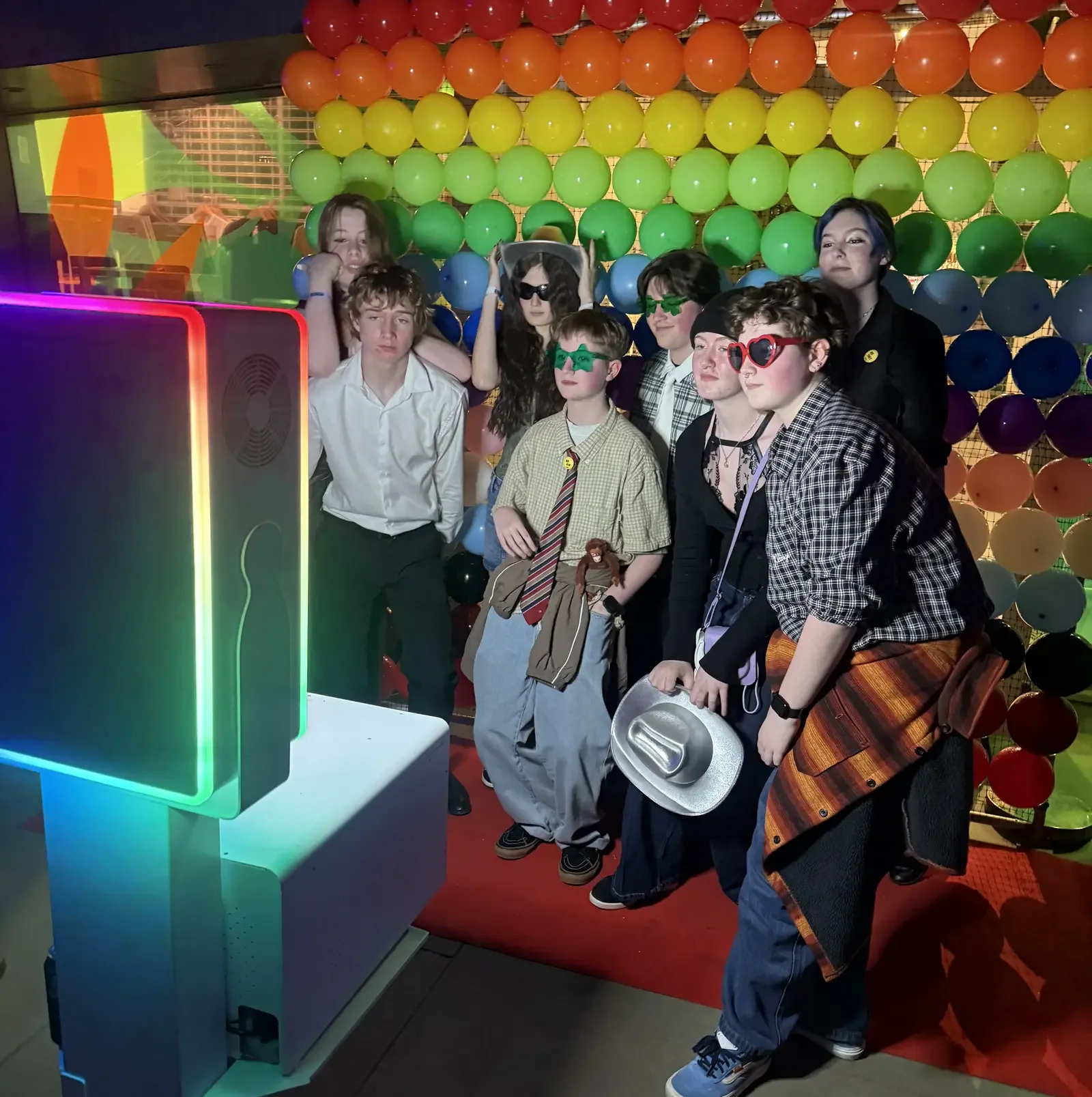 Queer Formal guests using the Bonds sponsored photo booth with Pride themed props