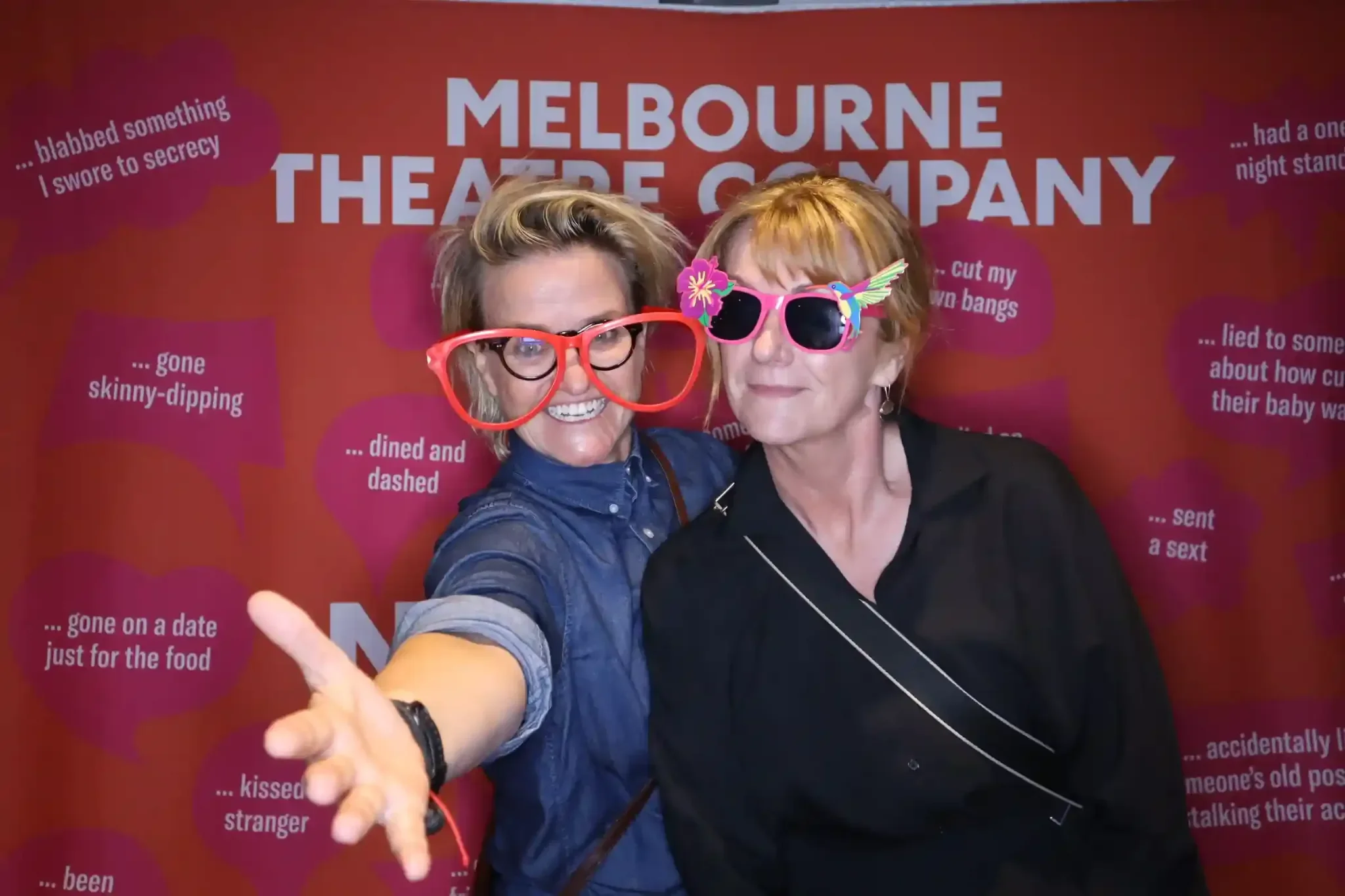 Office party photo booth hire Melbourne guests posing at a branded company event backdrop