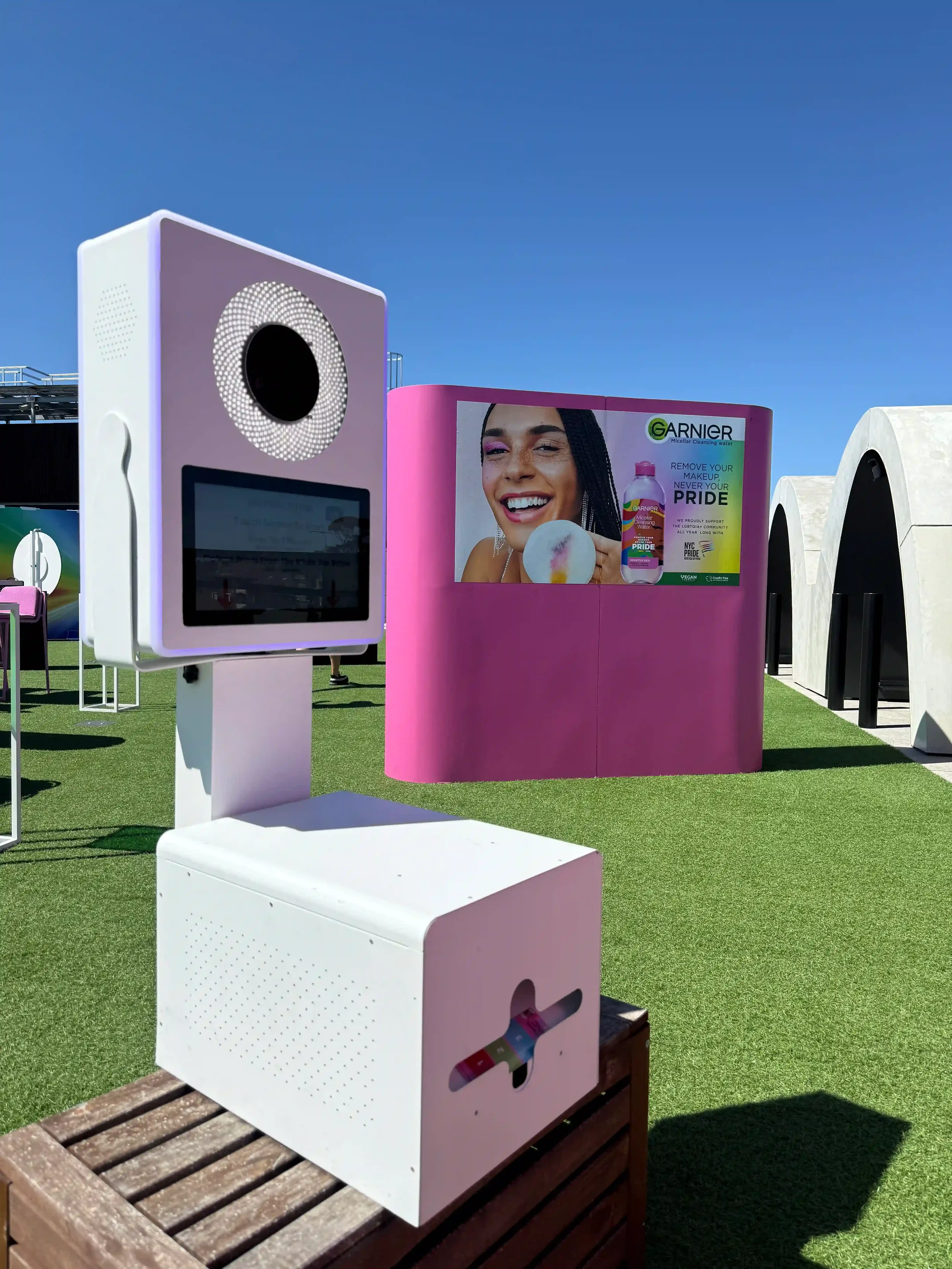 Garnier photo booth setup with curved pink branded backdrop wall