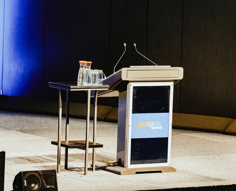 Speaker at the branded GCAP podium during a Melbourne conference session