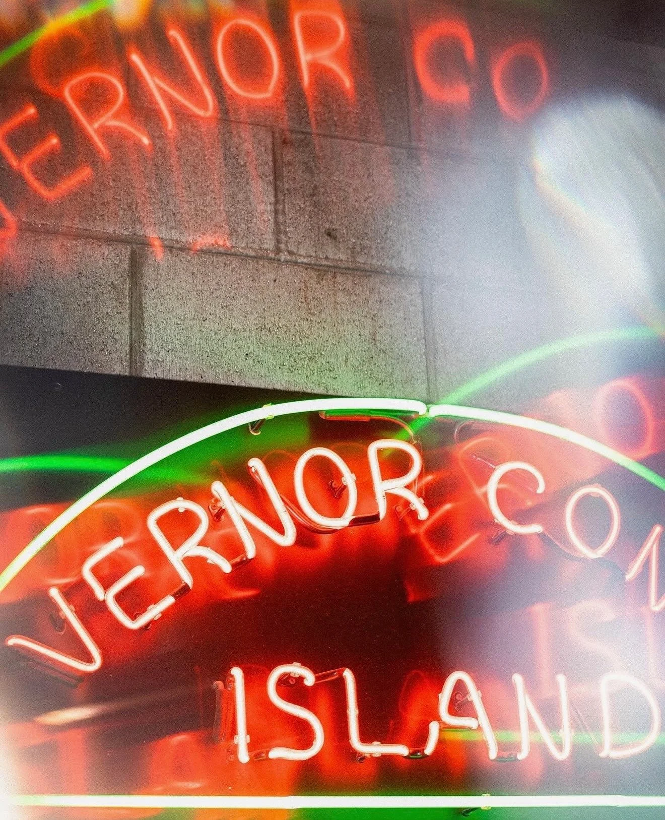 Red and green Vernor Coney Island neon reflected in glass.