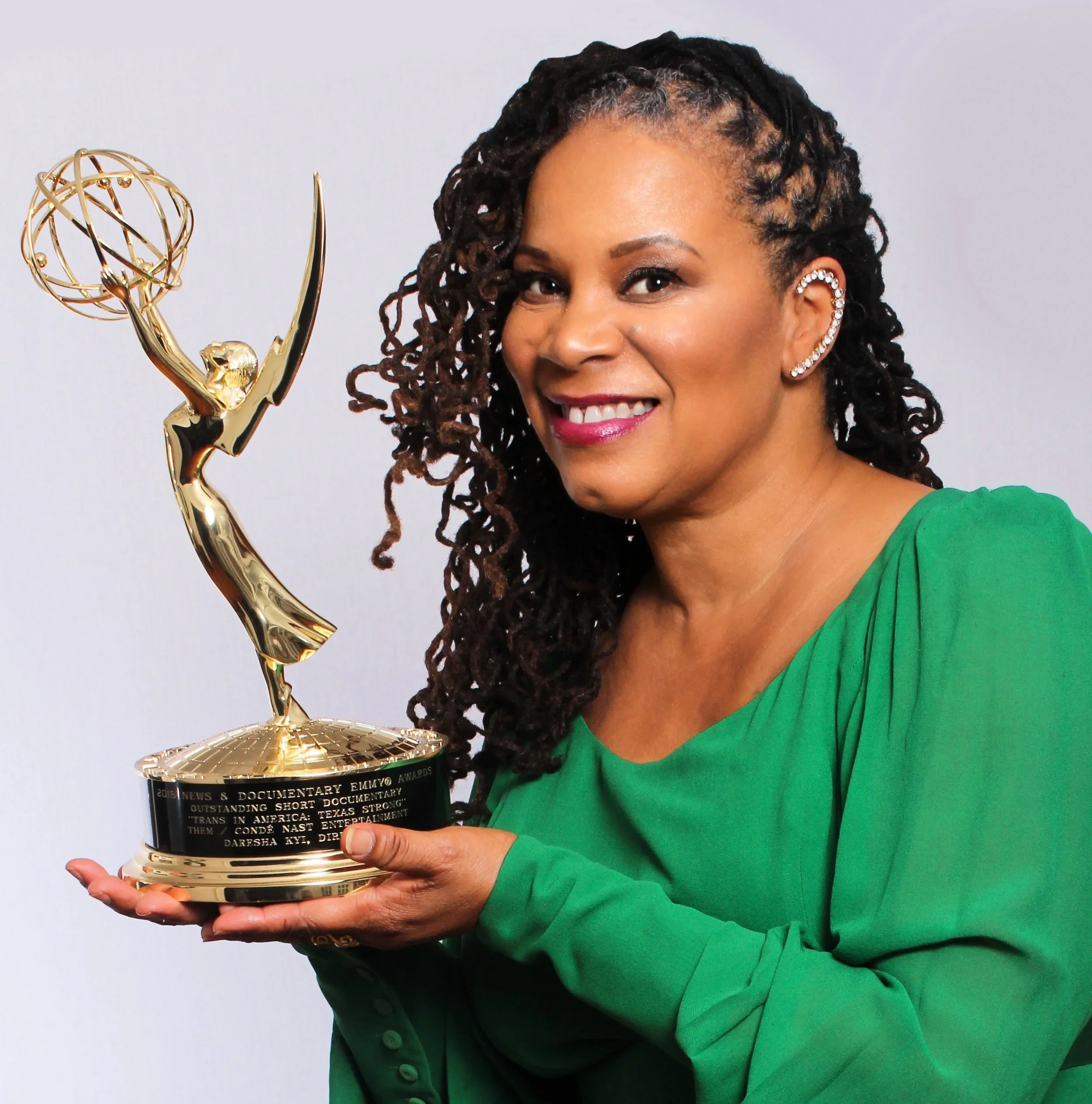 Daresha Kyi holding an Emmy statuette.