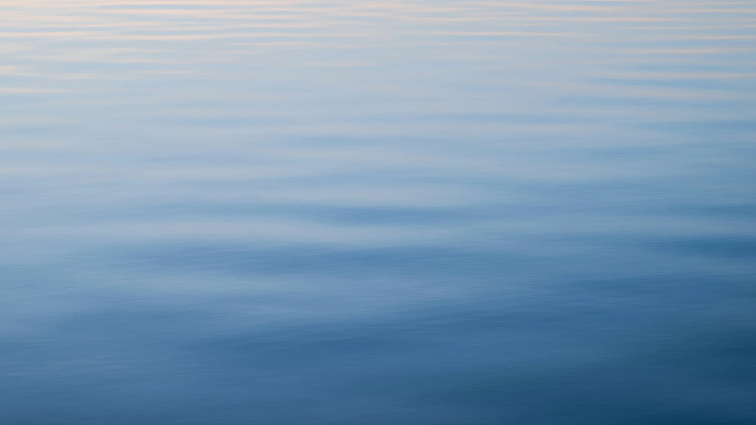 Gentle ripples across calm blue water.