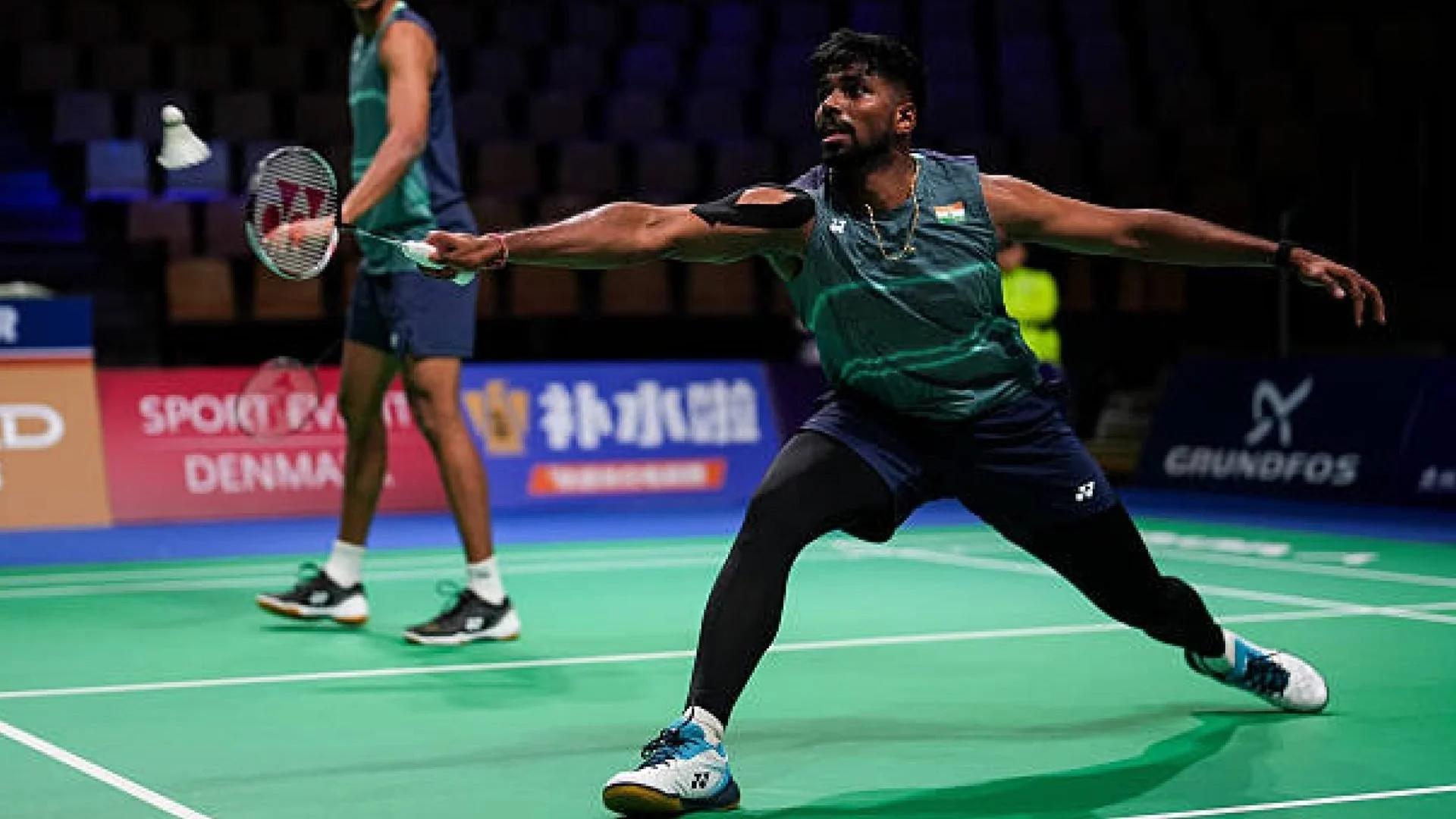 Satwiksairaj Rankireddy stretches for a shuttle, with Chirag Shetty behind him