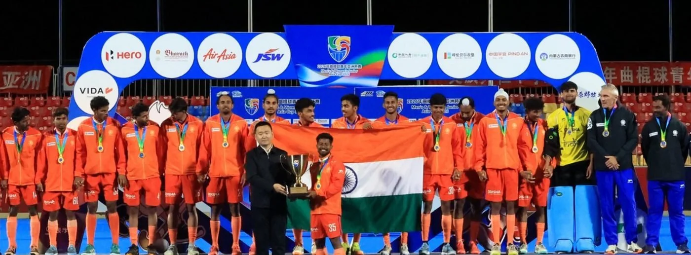 India's junior men with the Junior Asia Cup trophy and the Indian flag
