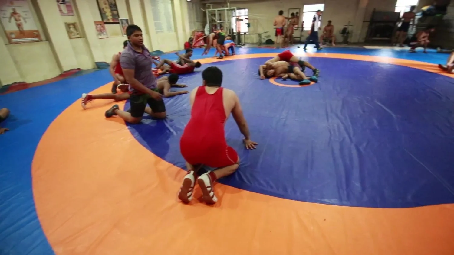 Wrestlers drill in pairs in the mat hall