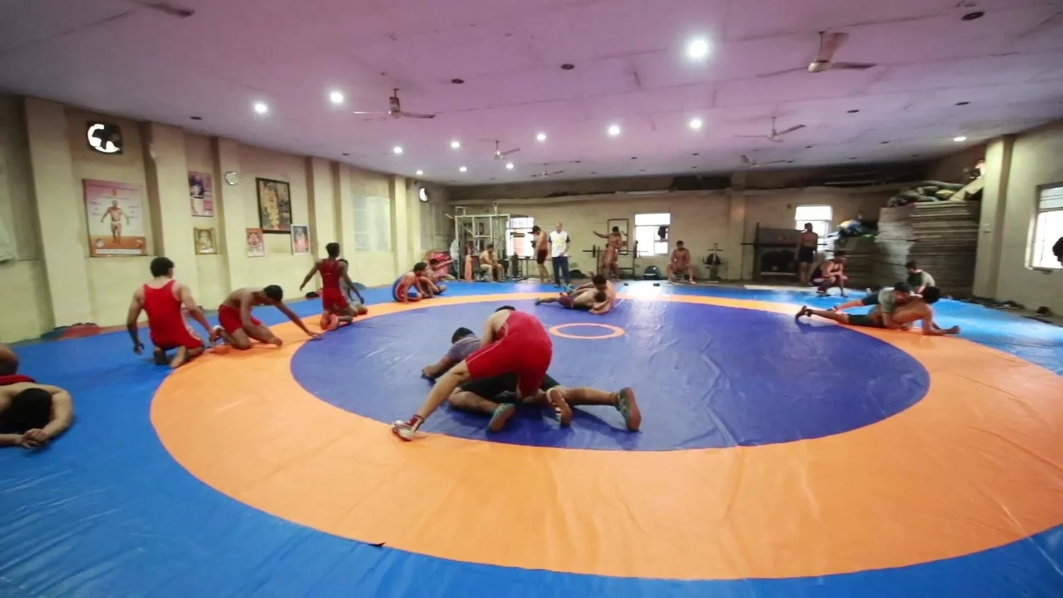Wrestlers train on the mats in the indoor hall