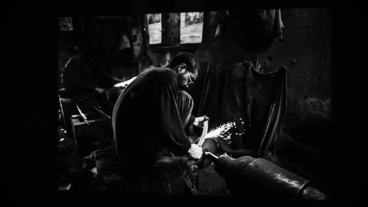 Frame 9 of 14: The karigar bent over his grinder