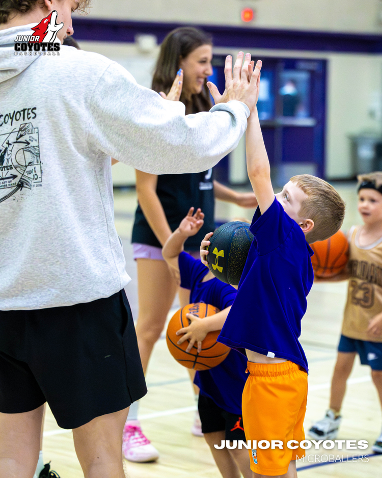 Coach Oaklen Kowal high fiving a young Junior Coyotes player