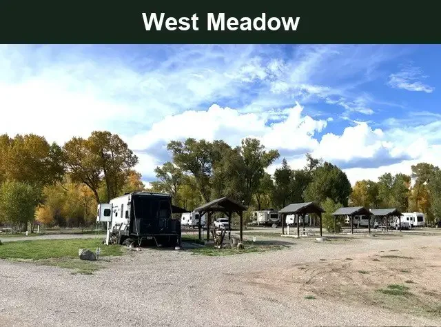 West Meadow RV site area with an RV, covered shelters and autumn trees at Woods and River RV Park.