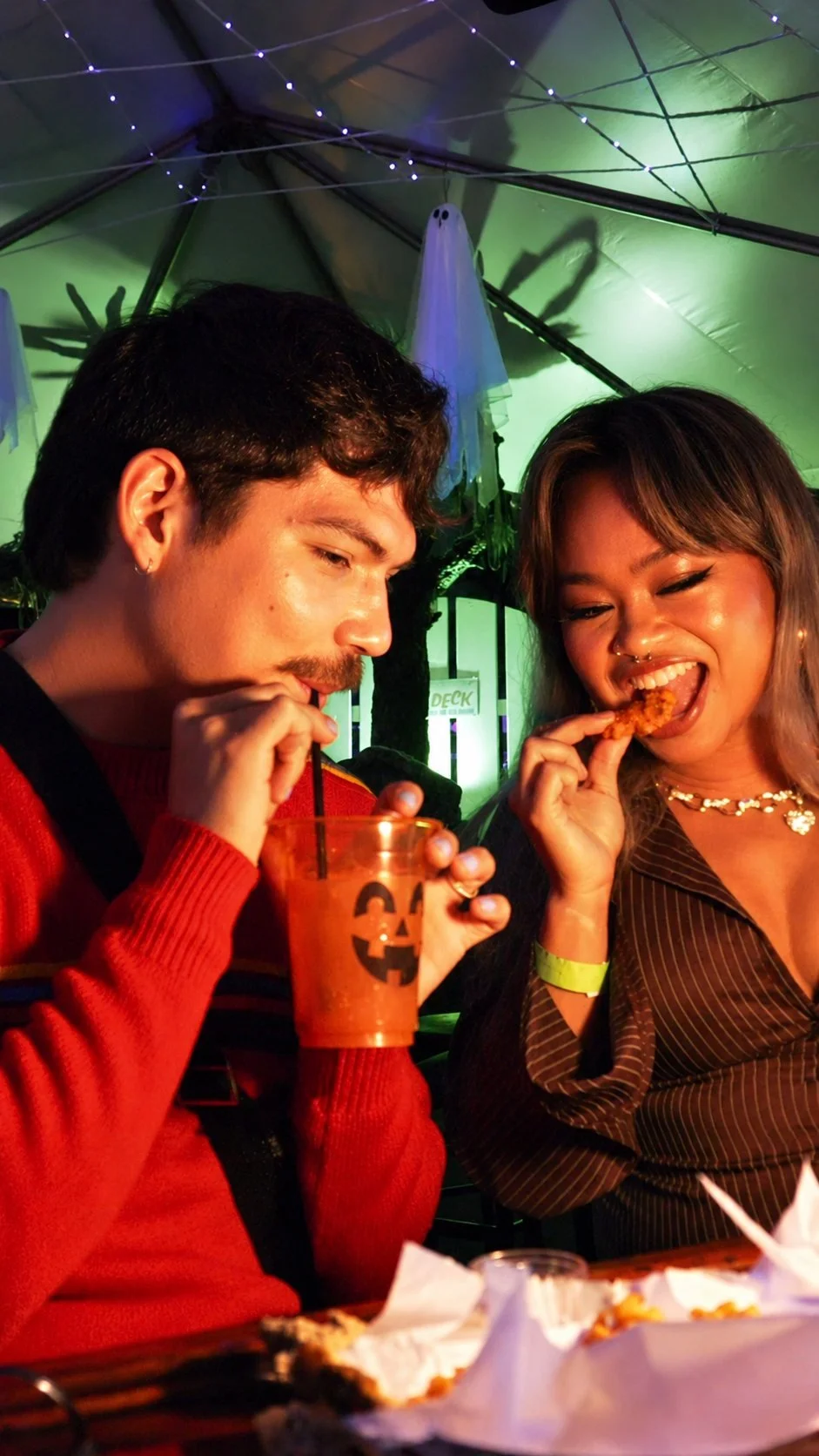 Guests enjoying food and drinks under the Haunted Pier tent