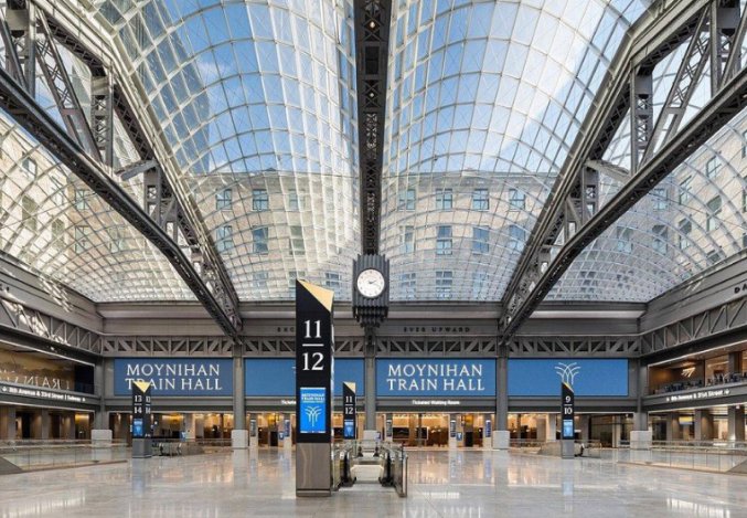 Penn Station transportation hub Interior view of a spacious building featuring expansive glass walls, allowing natural light to illuminate the space. Amtrak New York, NY
