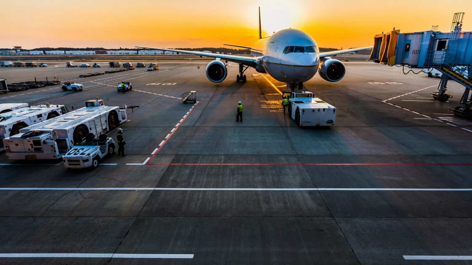 A commercial airplane stationary on the airport tarmac, surrounded by ground equipment.