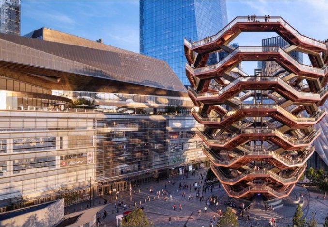 Hudson Yards New York City skyline viewed from a rooftop, showcasing iconic skyscrapers against a clear blue sky.