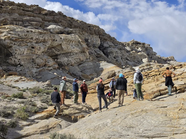 Class on honeycombed sandstone outcrop