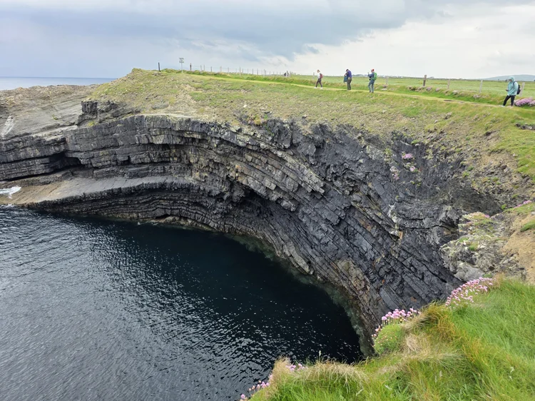 Sea arch and cliffs with people