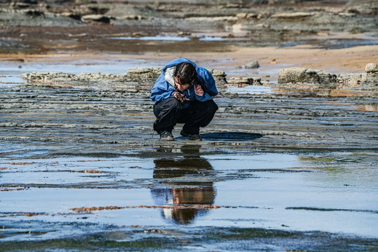 Student on reflective tidal flat