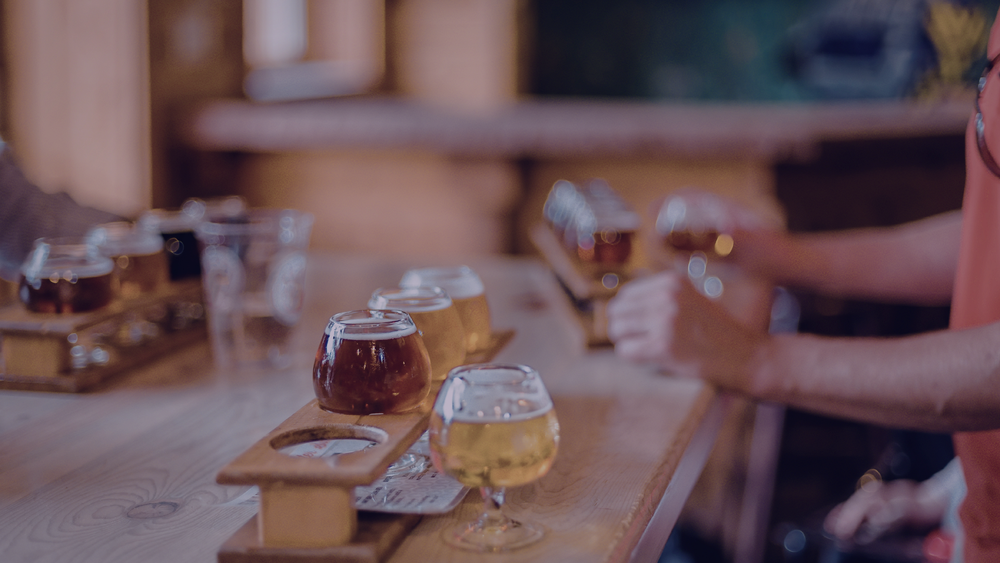 Beer flights lined up on a taproom bar