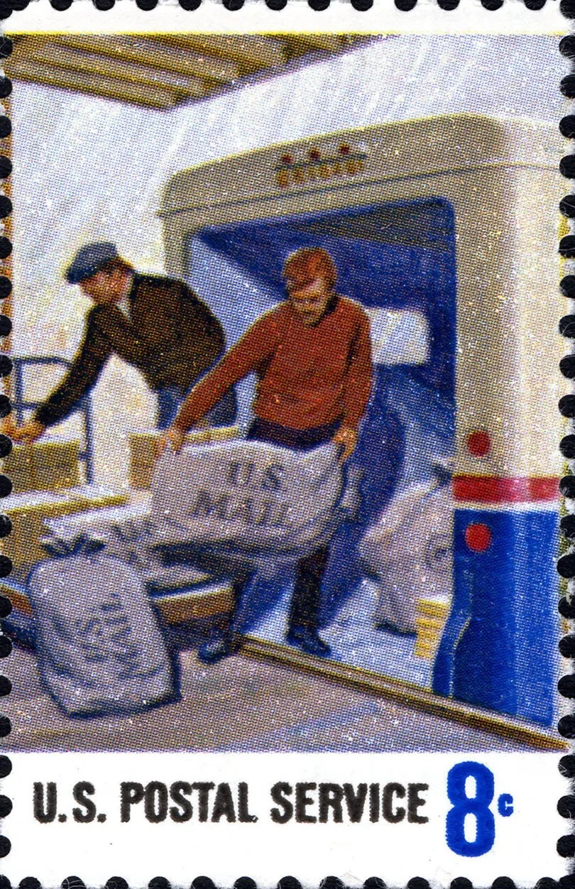 A vintage postage stamp showing bags of mail being loaded onto a mail truck