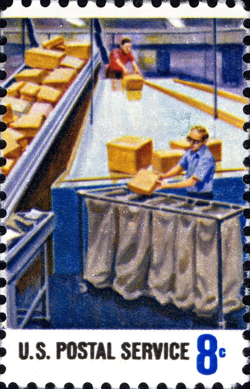 A vintage postage stamp showing mail boxes being sorted into carts