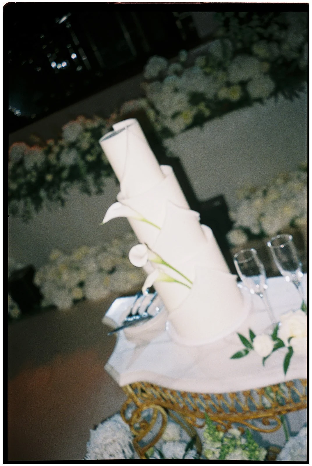The wedding cake and white calla lilies photographed on film