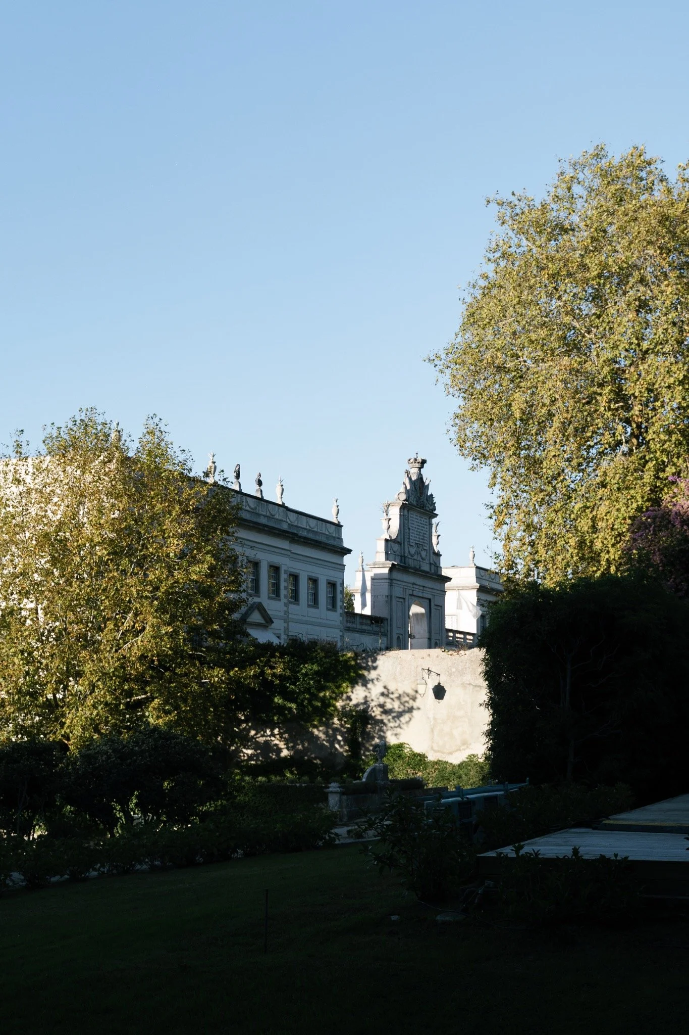 Sunlit trees and the palace seen from the gardens of Seteais