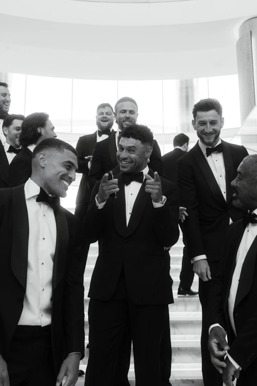Alex smiling with his groomsmen in black tie