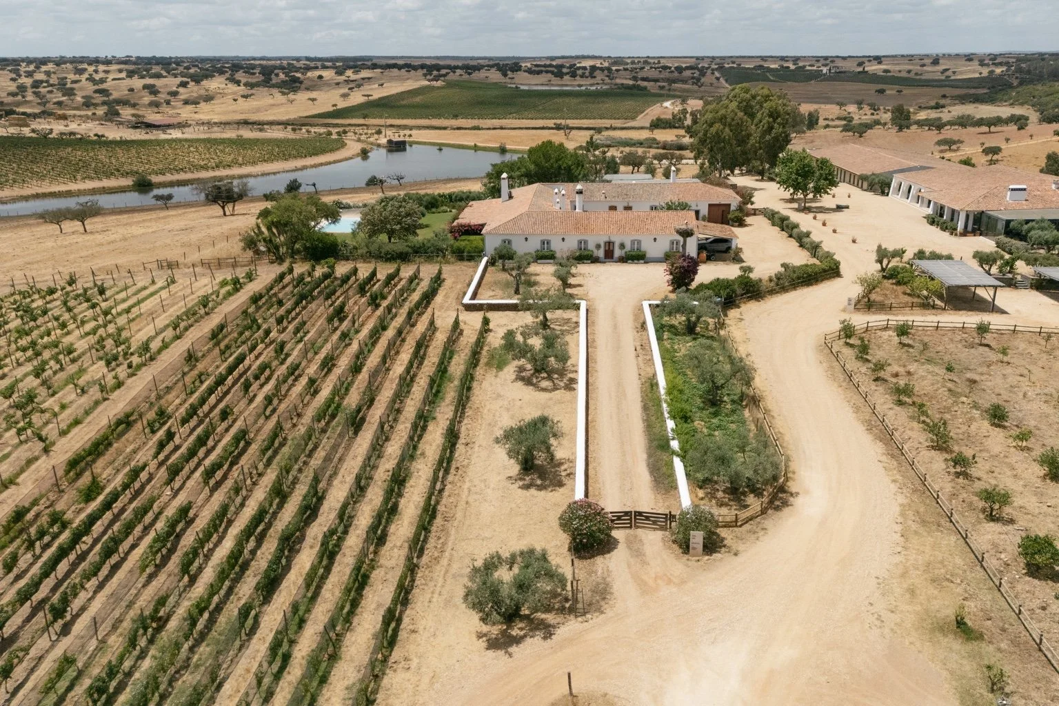 Aerial view of the white buildings and vineyards at Herdade da Malhadinha Nova.