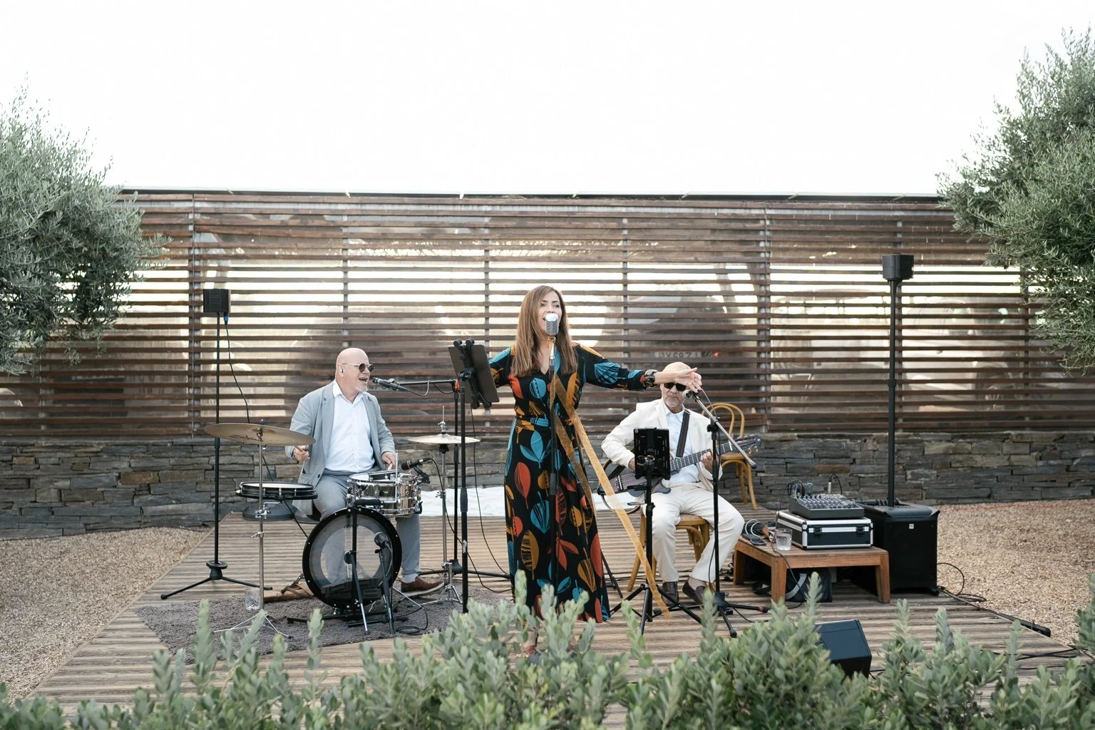 Three musicians performing outdoors at the welcome gathering.