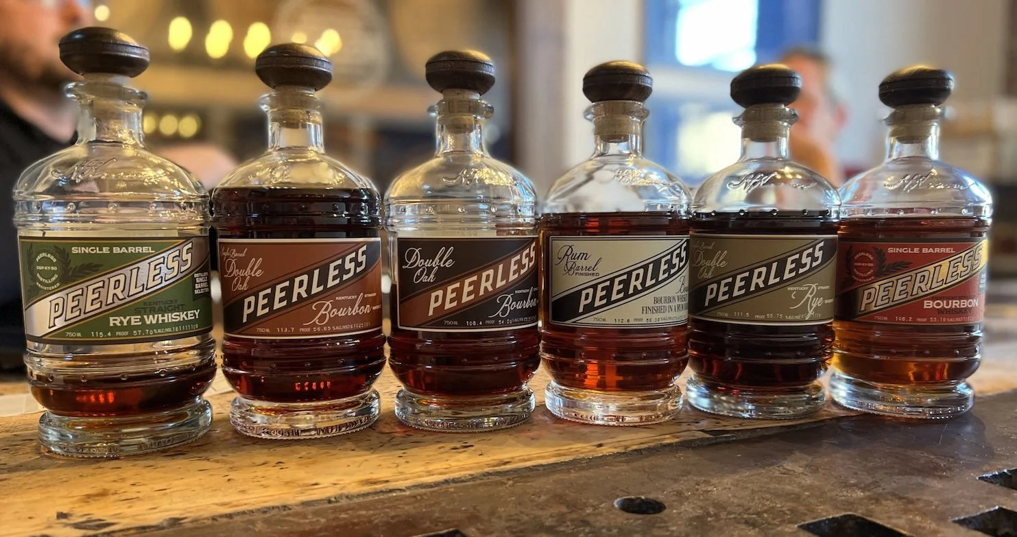 Full Kentucky Peerless whiskey lineup on a barrel at the distillery tasting room