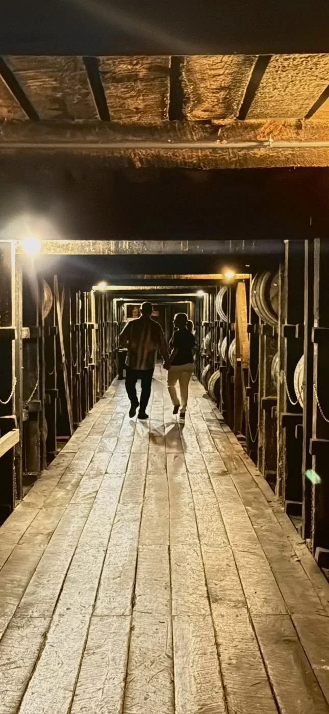 Looking down a long rickhouse aisle lined with bourbon barrels in Bardstown, Kentucky.