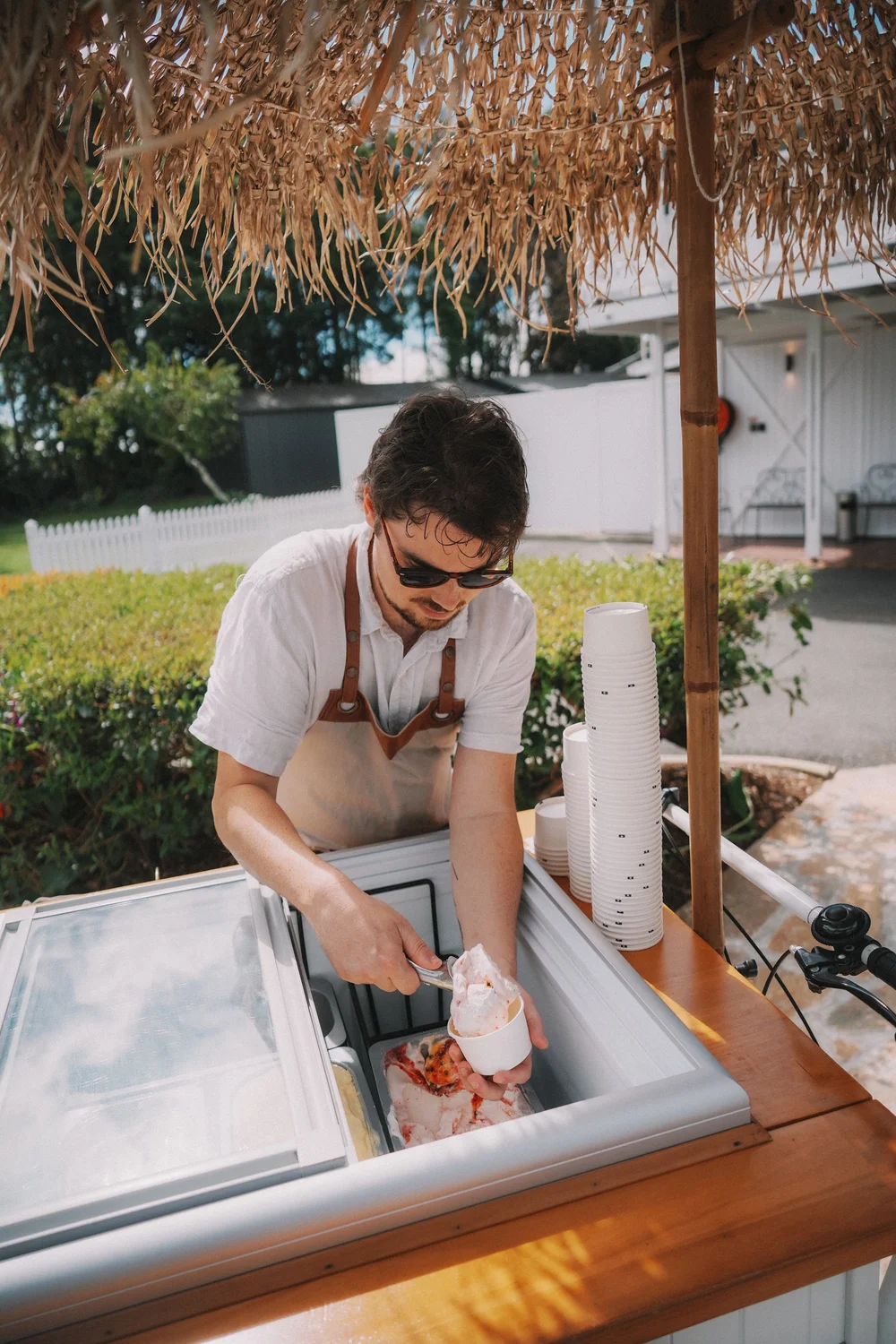 Scooping gelato under the tiki umbrella
