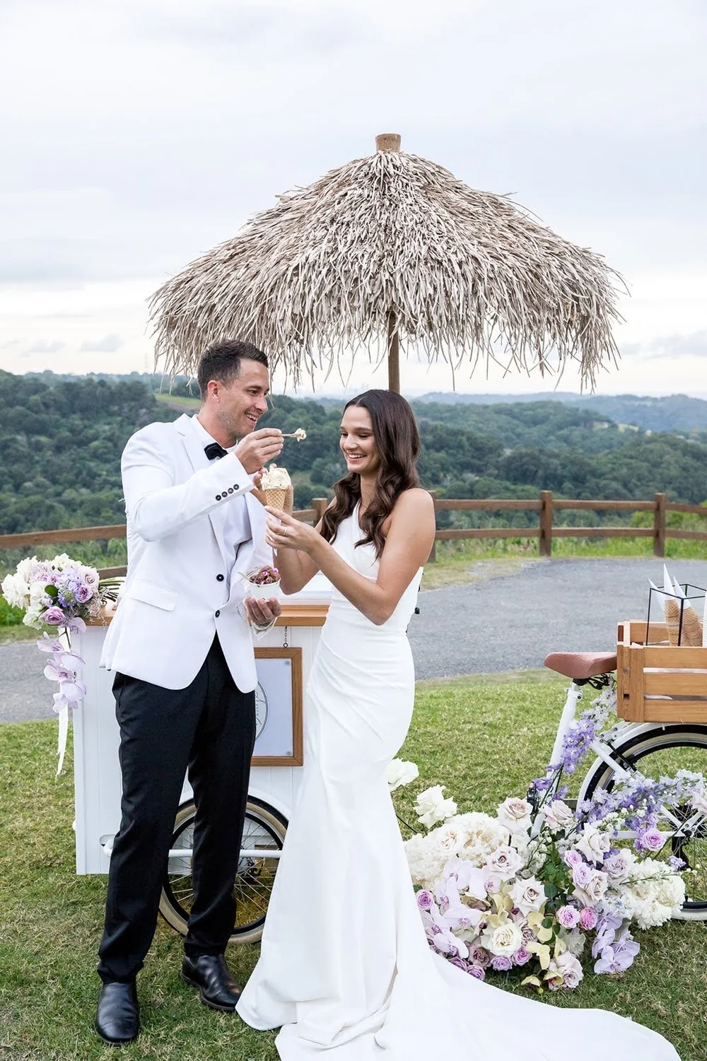 Newlyweds sharing gelato under the tiki umbrella