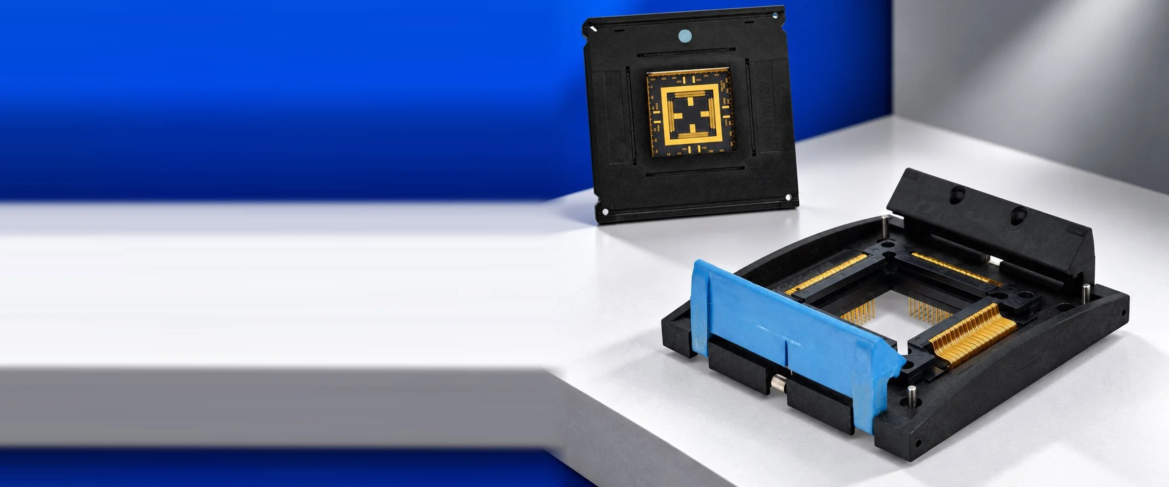 Azimuth Electronics high pin-count IC socket with blue latch and gold contacts, with a mounted device carrier in the background
