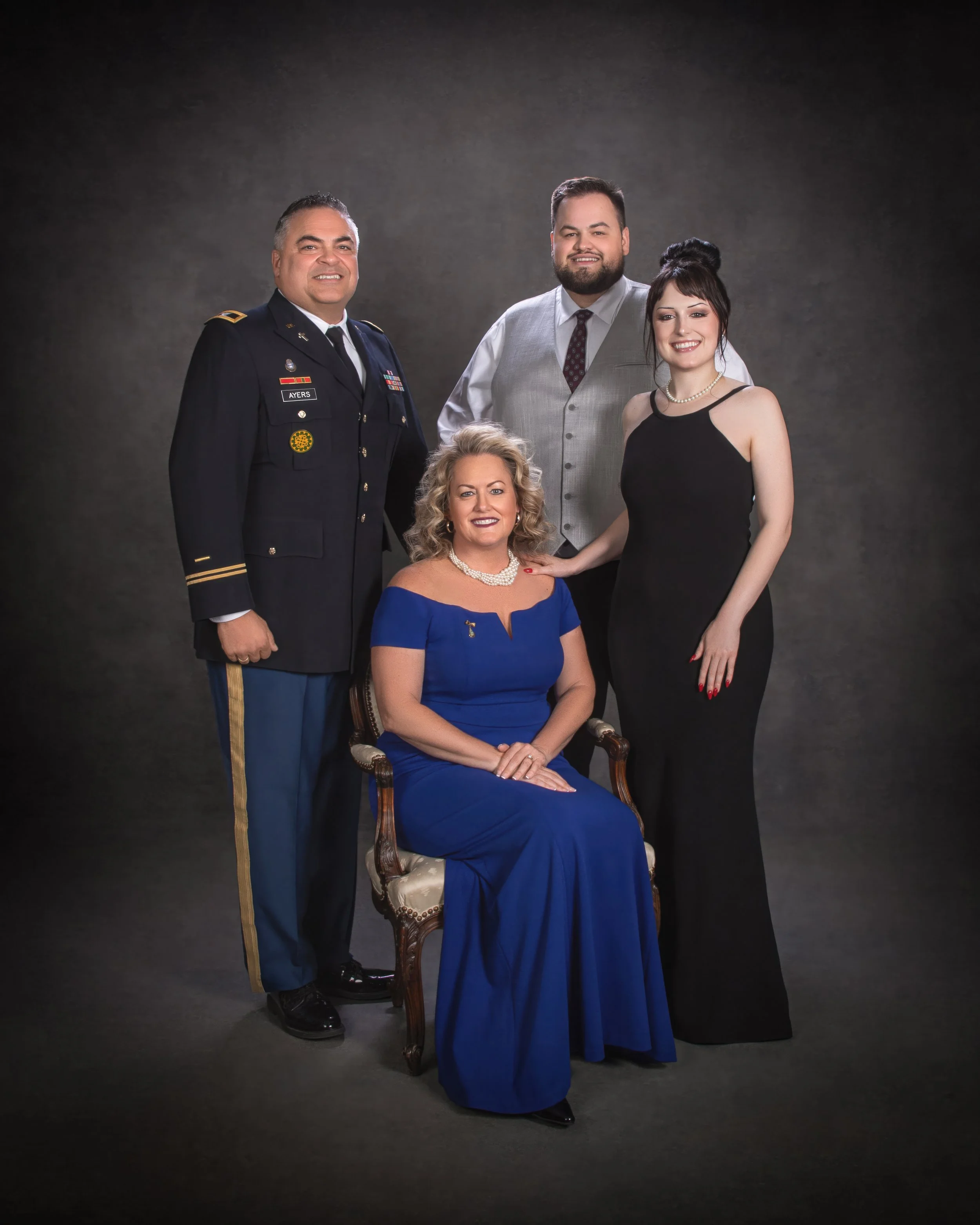 A family of four in formal dress, the father in military uniform, photographed in the studio