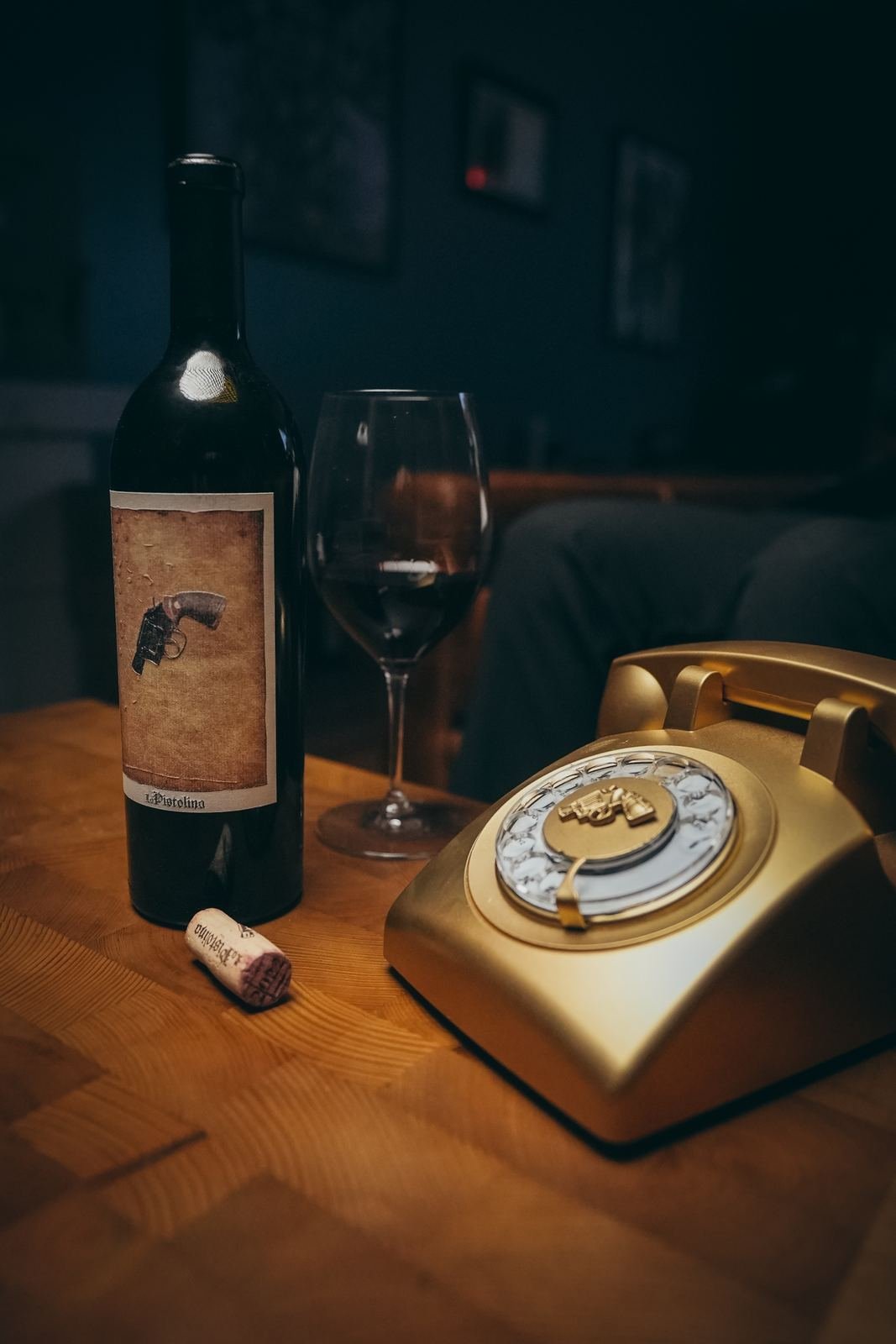 La Pistolina wine beside a gold telephone in a dark campaign setting